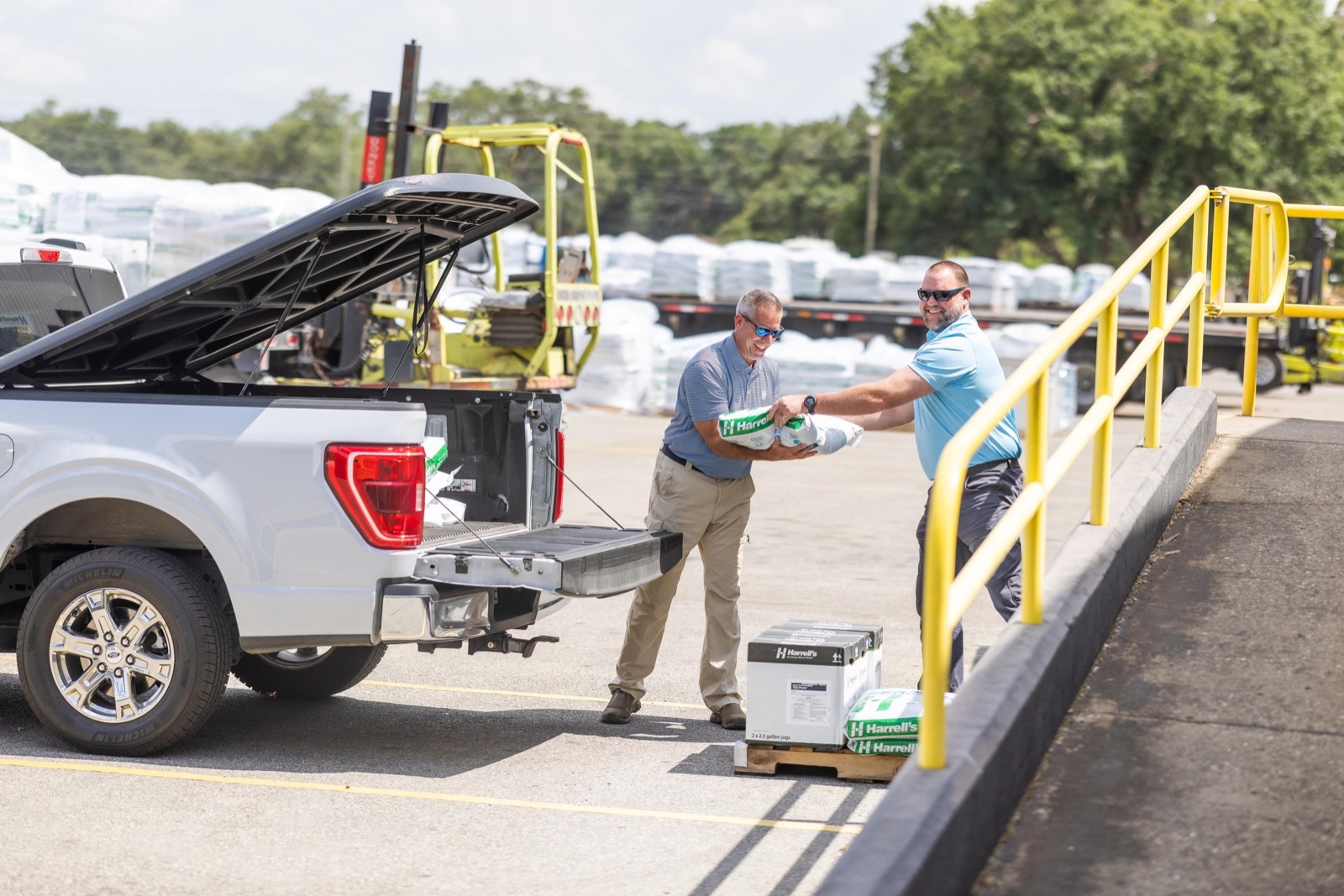 Harrell's team loading fertilizer into a pickup truck