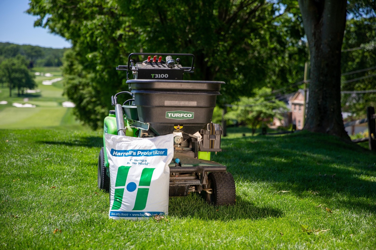 Harrell's fertilizer bag on a spreader on a green lawn